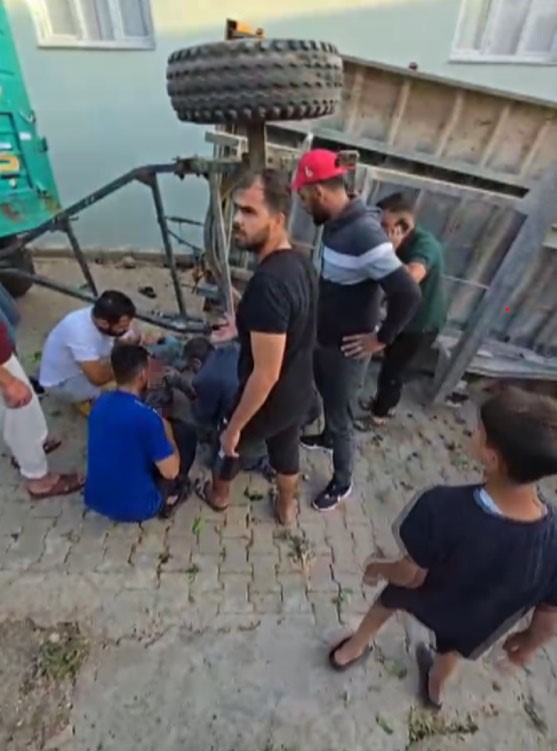 Hatay’da kontrolden çıkarak devrilen saman yüklü traktörün römorkunun altında kalan