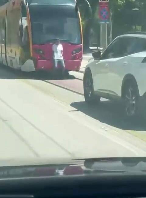 Bursa’da seyir halindeki tramvayın arkasında tutunarak seyahat eden gencin tehlikeli