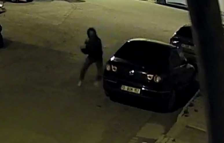 Karaman’da kafasına motosiklet kaskı takan bir kişi park halindeki otomobile